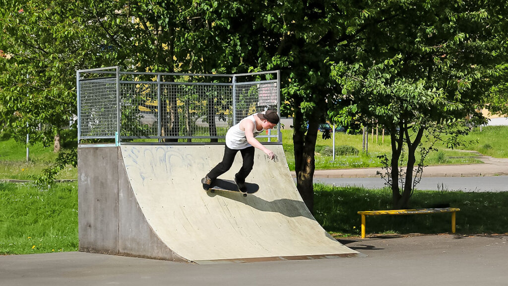 Ein Junge fährt ein Element einer Skateranlage herunter