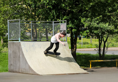 Ein Junge fährt ein Element einer Skateranlage herunter
