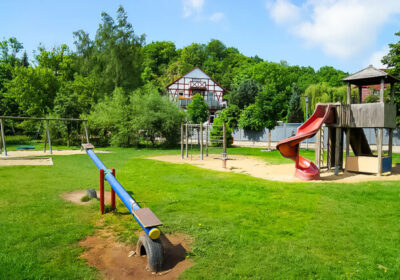 Spielgerät und Wippe auf dem Rasen in einem Park
