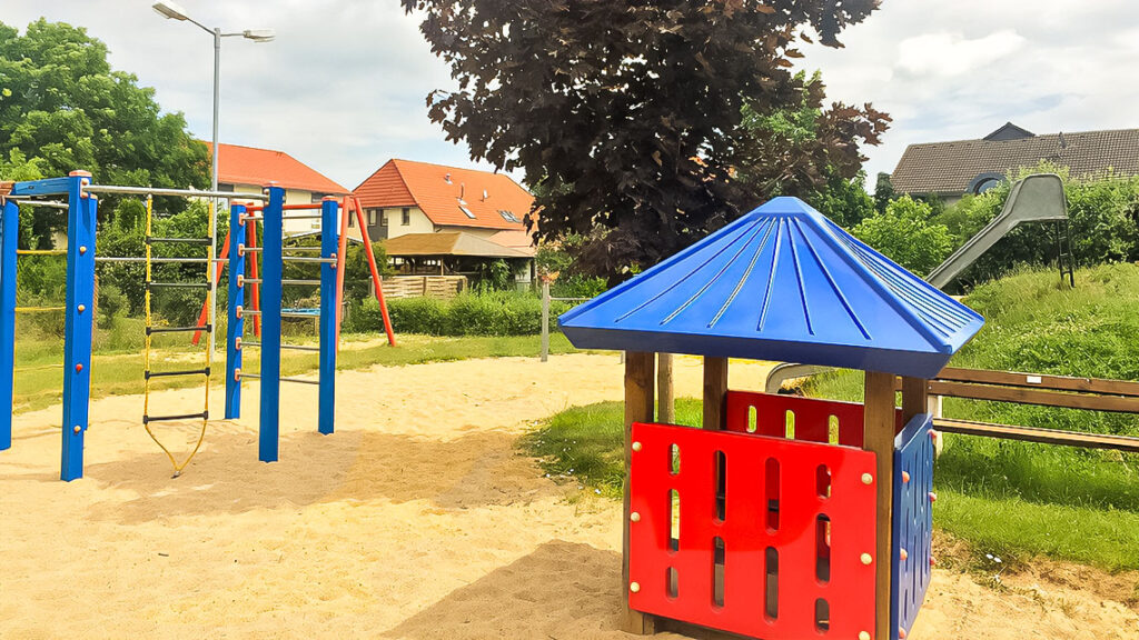 Spielgeräte, eine Rutsche und eine Sandfläche auf einem Spielplatz