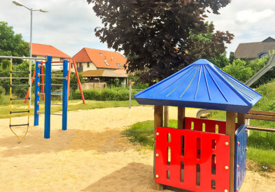 Spielgeräte, eine Rutsche und eine Sandfläche auf einem Spielplatz