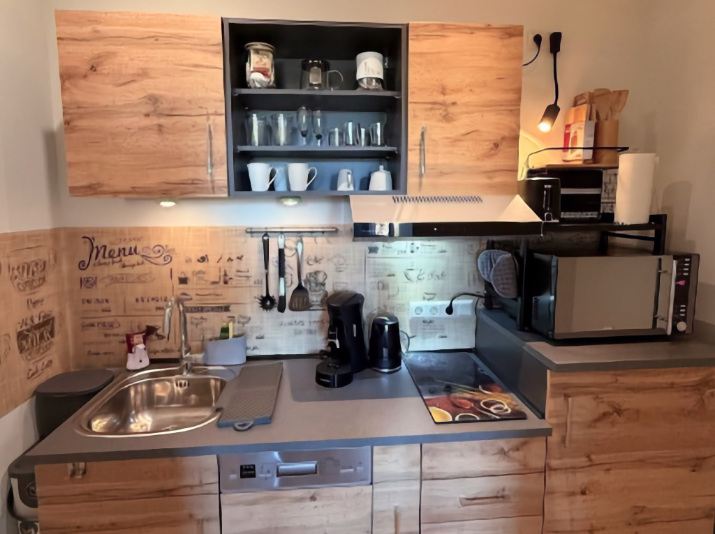 Foto einer voll ausgestatteten Ferienwohnung-Küche mit Schränken, Herd, Mikrowelle usw.